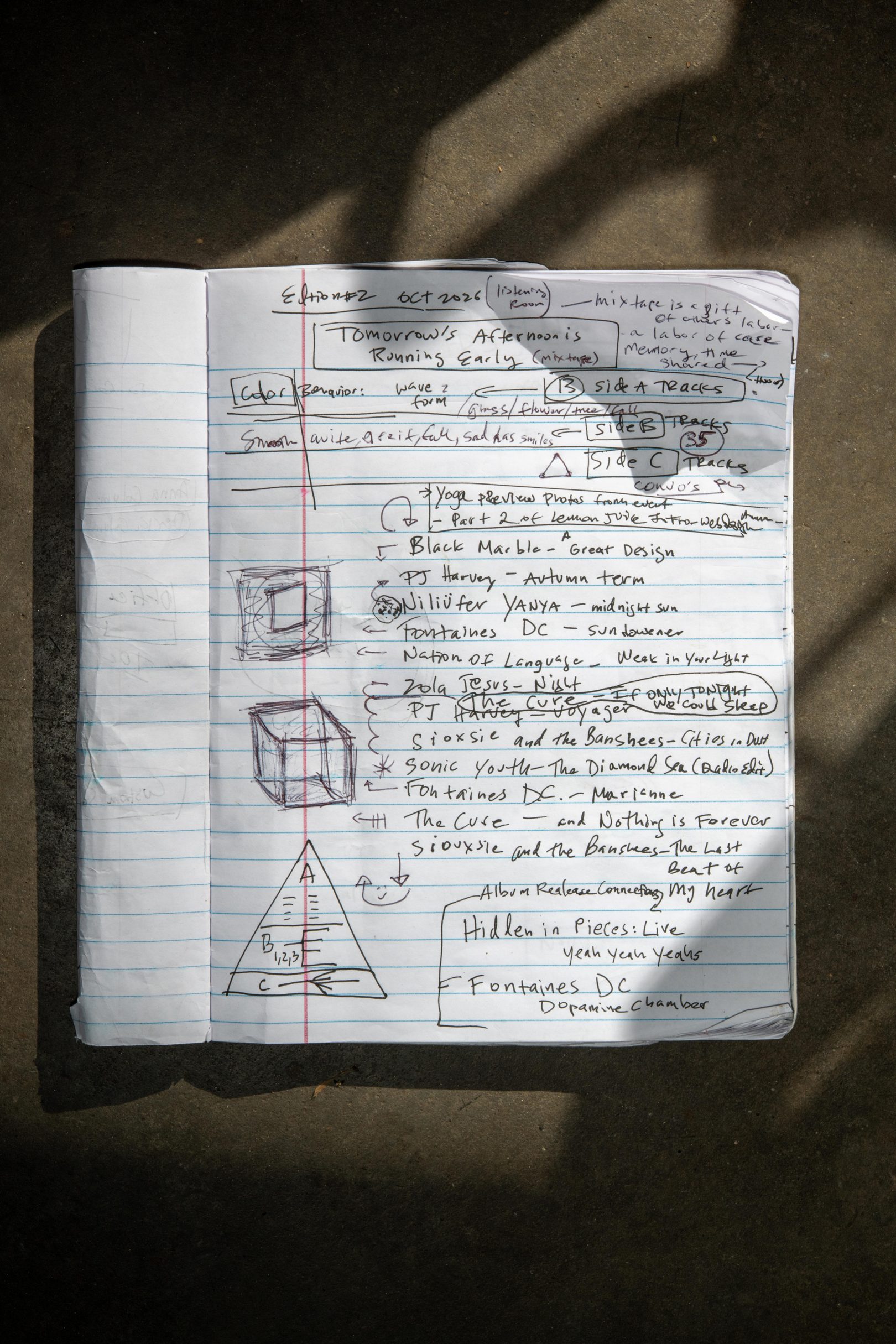 Original notebook photograph with handwritten notes, provisional music selections and early A/B/C pyramid sketches.